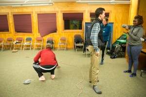 Tyler yells commands that are communicated to him by Mary Grace to the blindfolded Chris.